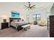 Main bedroom with a tray ceiling, ceiling fan, and large windows at 4711 Cedron Ct, Sarasota, FL 34240