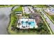 Aerial view of a stunning pool area with palm trees, lounge chairs, and a tennis court by the community clubhouse at 4711 Cedron Ct, Sarasota, FL 34240