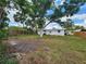 Spacious backyard featuring mature trees, partial fencing, and the exterior view of the back of the house at 4712 Cronin Dr, Sarasota, FL 34232