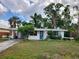 Charming one-story home featuring a bright blue door, manicured landscaping, and a welcoming entrance at 4712 Cronin Dr, Sarasota, FL 34232
