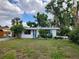 Inviting one-story residence with a blue front door, lush greenery, and a well-kept lawn at 4712 Cronin Dr, Sarasota, FL 34232
