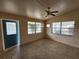 Bright living room with large windows, a ceiling fan, and a welcoming teal front door at 4712 Cronin Dr, Sarasota, FL 34232