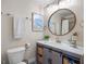 Well-appointed bathroom featuring a modern vanity with storage, a round mirror, and decorative accents at 4801 Sarasota Ave, Sarasota, FL 34234