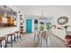 Well-lit dining area with modern light fixture, a turquoise front door, and breakfast bar at 4801 Sarasota Ave, Sarasota, FL 34234