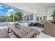 View of the screened in patio featuring an outdoor kitchen, dining table, and lounge area near the pool at 4801 Sarasota Ave, Sarasota, FL 34234