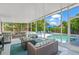 This screened patio features a grill, wood table, and outdoor seating overlooking the sparkling pool at 4801 Sarasota Ave, Sarasota, FL 34234