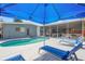 A refreshing private pool is featured with lounge chairs and shade near the screened patio at 4801 Sarasota Ave, Sarasota, FL 34234