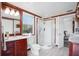 Bathroom with cherrywood vanity, shower, and open doorway to another room at 4806 Capri Ave, Sarasota, FL 34235