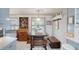 Cozy dining nook features tile floor, storage cabinet, a wooden table with bench seating and bright natural lighting at 4806 Capri Ave, Sarasota, FL 34235