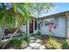 Inviting front entrance features a cozy bench, lush landscaping, and a brick walkway at 4806 Capri Ave, Sarasota, FL 34235