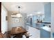 Open concept kitchen and dining area with stainless steel appliances, white tile floor, and light blue cabinetry at 4806 Capri Ave, Sarasota, FL 34235