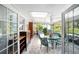 Enclosed patio with skylights, tile floors, and outdoor furniture overlooking a beautiful private pool and garden at 4806 Capri Ave, Sarasota, FL 34235