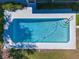 Aerial view of a sparkling rectangular pool with clean, clear blue water, surrounded by concrete patio and landscaping at 4806 Capri Ave, Sarasota, FL 34235