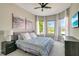 Light-filled bedroom with a ceiling fan, bay windows, and a comfortable bed and matching nightstands at 5673 Piccolo St, Nokomis, FL 34275
