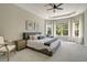 Airy bedroom with tray ceilings, lots of natural light, and a cozy gray sitting area at 5673 Piccolo St, Nokomis, FL 34275