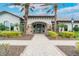 Community clubhouse entrance with stone accents, arched doorway, and lush landscaping at 5673 Piccolo St, Nokomis, FL 34275
