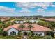 Aerial perspective of a community center with a tile roof, surrounding palm trees, and serene lake views at 5673 Piccolo St, Nokomis, FL 34275