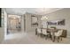Elegant dining room with modern chandelier, seating for six, and large artwork on the wall at 5673 Piccolo St, Nokomis, FL 34275