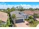 Exterior view of a well-maintained single-Gathering home featuring a gray roof and lush landscaping at 5673 Piccolo St, Nokomis, FL 34275