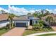 Beautiful single-story home with a tile roof, lush landscaping, a brick driveway, and an attached two-car garage at 5673 Piccolo St, Nokomis, FL 34275