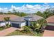 Landscaped single-story home with a tile roof, brick driveway, tropical plants, and an attached two-car garage at 5673 Piccolo St, Nokomis, FL 34275