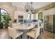 Bright kitchen with white cabinetry, a granite island with bar seating, stainless steel appliances, and arched windows at 5673 Piccolo St, Nokomis, FL 34275