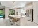 Bright, white kitchen features stainless steel appliances, a large island, and seamless access to outdoor spaces at 5673 Piccolo St, Nokomis, FL 34275