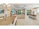 Open-concept living room and dining area features modern lighting, neutral decor, and sliding glass doors leading to the lanai at 5673 Piccolo St, Nokomis, FL 34275