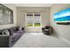 Inviting living room with a couch, comfortable armchair, and large windows overlooking the landscaped outdoors at 5673 Piccolo St, Nokomis, FL 34275