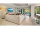 Cozy living room featuring an expansive sectional sofa, views of the pool, and neutral decor at 5673 Piccolo St, Nokomis, FL 34275