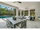 Spacious screened-in lanai with outdoor dining and lounging areas, offering beautiful views of the pool and lush backyard at 5673 Piccolo St, Nokomis, FL 34275