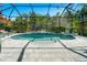 Beautiful screened-in pool and spa with blue tile accents surrounded by a light gray tiled patio and lush greenery at 5673 Piccolo St, Nokomis, FL 34275
