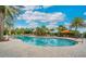 Inviting community pool area with ample lounge chairs, umbrellas and lush landscaping in the background at 5673 Piccolo St, Nokomis, FL 34275