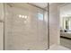 Modern bathroom with large frameless glass shower, marble tile, and chrome fixtures, complemented by natural light at 5673 Piccolo St, Nokomis, FL 34275