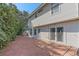 Backyard features a brick patio and is surrounded by green bushes, trees, and white siding at 5766 Forester Pine Ct, Sarasota, FL 34243