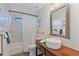 Bathroom features a vessel sink, decorative mirror, bathtub with white shower curtain, and wood-style floor at 5766 Forester Pine Ct, Sarasota, FL 34243