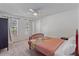 Bright bedroom with a ceiling fan, two windows, and an red-colored bed with a colorful quilt at 5766 Forester Pine Ct, Sarasota, FL 34243
