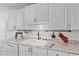 Kitchen featuring white cabinets, granite countertops, stainless steel dishwasher and ample storage at 5766 Forester Pine Ct, Sarasota, FL 34243