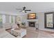Bright living room featuring a fireplace, ceiling fan, and neutral decor at 5766 Forester Pine Ct, Sarasota, FL 34243