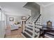 Cozy living room with fireplace adjacent to staircase with decorative painting and woodwork at 5766 Forester Pine Ct, Sarasota, FL 34243