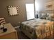 Cozy bedroom featuring a comfortable bed with quilted comforter, a window with blinds, and a decorative mirror at 5767 Avista Dr # 5767, Sarasota, FL 34243