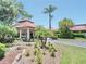 Exterior of clubhouse with tropical landscaping, a circular driveway, and a tile roof at 5767 Avista Dr # 5767, Sarasota, FL 34243