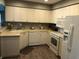 Clean kitchen with white cabinets, a breakfast bar, tile floors, and white appliances at 5767 Avista Dr # 5767, Sarasota, FL 34243