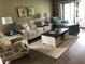 Comfortable living room with sofa, chair, side tables, lamps, rug, and access to outdoor patio at 5767 Avista Dr # 5767, Sarasota, FL 34243