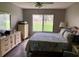 Cozy bedroom with large window overlooking the lawn, wooden dresser, and comfortable queen bed at 5767 Avista Dr # 5767, Sarasota, FL 34243