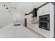 Chic kitchen featuring white cabinets, stainless steel appliances, a quartz countertop island, and modern fixtures at 5838 Meriwether Pl, Sarasota, FL 34232