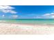 Expansive beach view featuring soft sand, turquoise water, and clear blue skies at 605 Sutton Pl # 401-A, Longboat Key, FL 34228