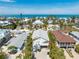 Expansive aerial shot showcases this delightful coastal home surrounded by mature landscaping and ocean views at 612 Fern St, Anna Maria, FL 34216
