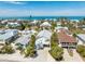 Stunning aerial view of a charming coastal home nestled among lush trees with the ocean in the background at 612 Fern St, Anna Maria, FL 34216