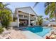 Beautiful backyard featuring a sparkling pool, outdoor seating, and lush landscaping at 612 Fern St, Anna Maria, FL 34216